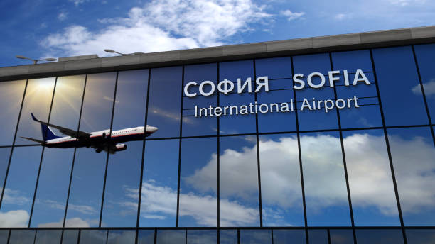 Airplane landing at Sofia mirrored in terminal stock photo