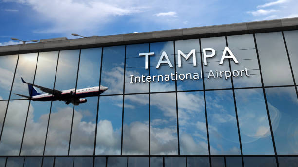 Airplane landing at Tampa Florida, USA airport mirrored in terminal stock photo