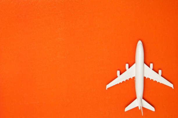 Airplane model. White plane on orange background. Travel vacation concept. Summer background. Flat lay. stock photo
