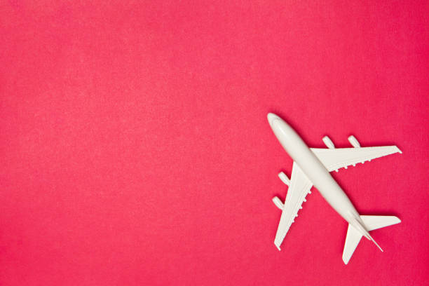 Airplane model. White plane on pink background. Travel vacation concept. Summer background. Flat lay. stock photo
