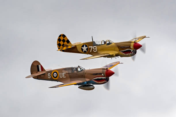Airplane P-40 Warhawk foghters flying in formation at air show Chino, California,USA - May 6,2017. Airplanes WWII P-40 Warhawk fighters flying together at 2017 Planes of Fame Air Show in Chino, California. The Planes of Fame Air Show features vintage and one-of-a-kind military and experimental aircraft that can only be seen at this air show. ww2 american fighter planes pictures stock pictures, royalty-free photos & images