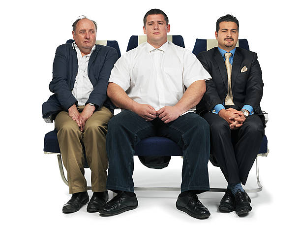 airplane tight seat a broadman sitting on ana airplane seat leaving very little room for people beside him airplane seat stock pictures, royalty-free photos & images