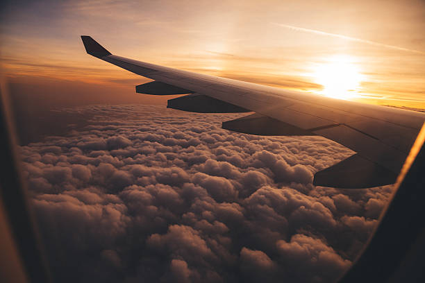 Airplane Wing in Flight view from airplane in flight with sunset altocumulus stock pictures, royalty-free photos & images