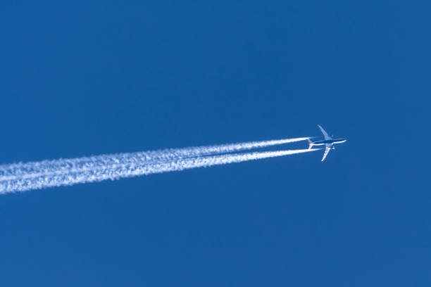 Airplanes leaving contrail trace on a clear blue sky. Airplanes leaving contrail trace on a clear blue sky private plane stock pictures, royalty-free photos & images