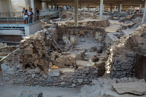 Akrotiri, Santorini Island, Greece - July 04, 2018: Akrotiri is an archaeological site from the  Cycladic Bronze Age on the Santorini Island. You can see ancient buildings, decorated pottery and people on the site.