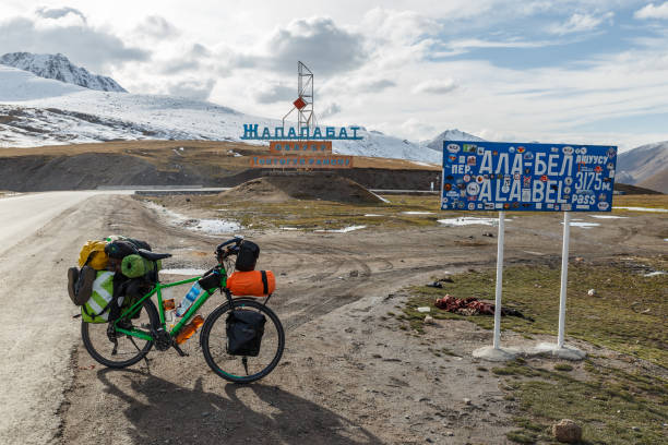 Ala Bel pass, Bishke-Osh highway Chuy Province, Kyrgyzstan - October 07, 2019: A tourist bike with bags is standing near the sign of Ala Bel Pass on the Bishkek-Osh highway M41 in Kyrgyzstan. tien shan mountains stock pictures, royalty-free photos & images