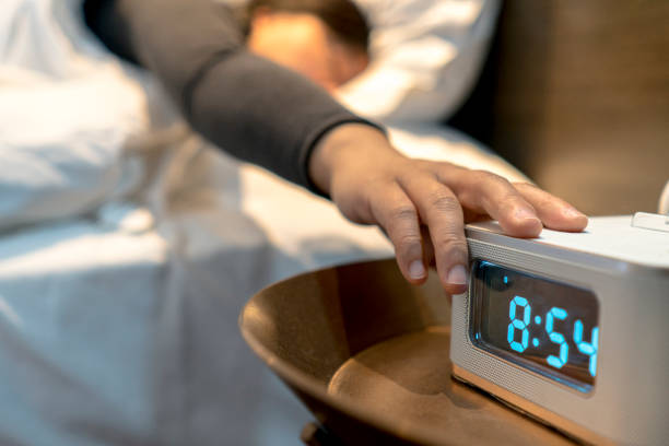 alarm clock at bedside stock photo