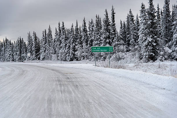Alaska Snow Covered Winter Road With Canada Border Sign stock photo
