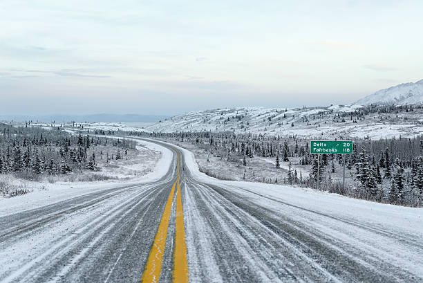 Alaska Winter Road and Sky With Distance Sign to Fairbanks stock photo