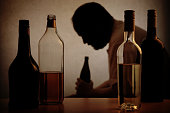 istock Alcohol bottles with the Silhouette of an alcoholic man 468735068