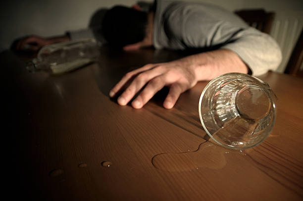 Alcoholism Concept Man Drunk Laying on the Table stock photo