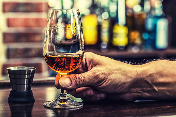 Alcoholism. Hand alcoholic and drink the distillate brandy or cognac. Alcoholism. Hand alcoholic and drink the distillate brandy whiskey  or cognac. bar drink establishment photos stock pictures, royalty-free photos & images