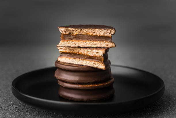 Alfajor with dulce de leche sweet pastry cake, a traditional Argentine dessert with chocolate and caramel Alfajor with dulce de leche sweet pastry cake, a traditional Argentine dessert with chocolate and caramel argentina food stock pictures, royalty-free photos & images