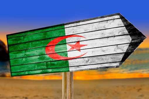 Algeria Flag wooden sign on beach background