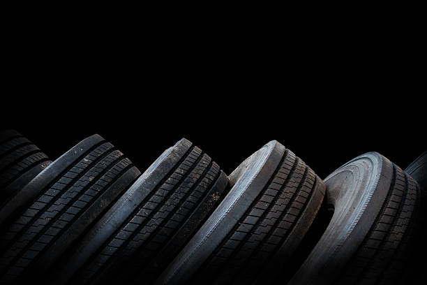 alignment of car tires in black background, used tires