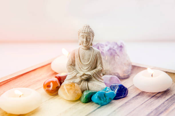 alla sju chakra färger kristaller stenar runt sittande buddha figurin på naturlig träbricka. balansera och lugna energiflöden i home concept. - kristall bildbanksfoton och bilder