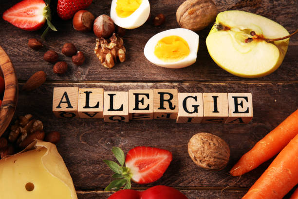 Allergy food concept. Allergy food as almonds, milk, cheese, strawberry, eggs, peanuts and 
crustaceans or shrimps with wooden letter in german allergie stock photo