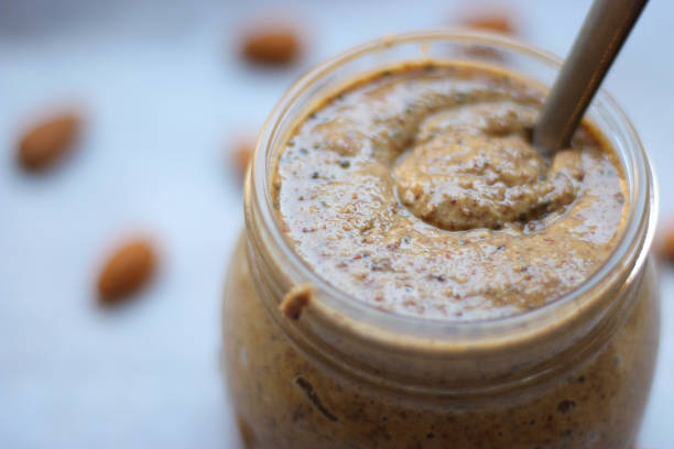 Almond butter close up homemade almond butter close up with wooden spoon almond butter stock pictures, royalty-free photos & images