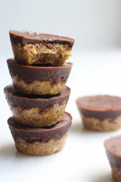 almond butter cups homemade almond butter cups stacked on white background almond butter stock pictures, royalty-free photos & images