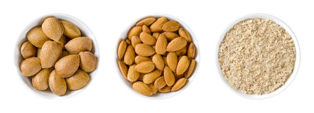 Almonds, with and without shells, and ground nuts, in white bowls stock photo