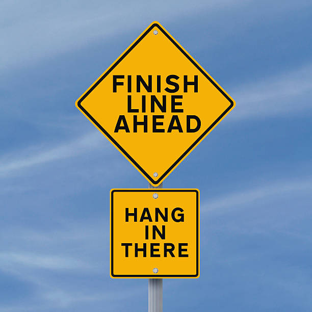 Almost There A road sign announcing the finish line just ahead approaching photos stock pictures, royalty-free photos & images