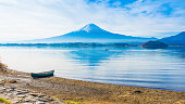 朝時間富士山を背景に河口湖の側の地面に一人で舟