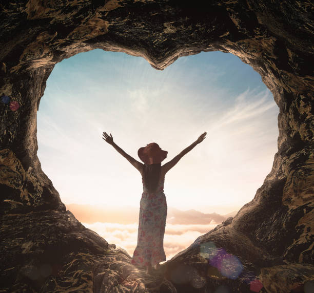 Alone woman standing on cave of heart stock photo