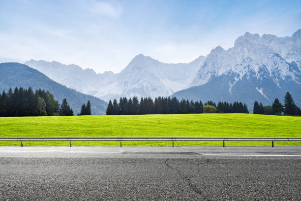 Alpine green meadow and asphalt road stock photo