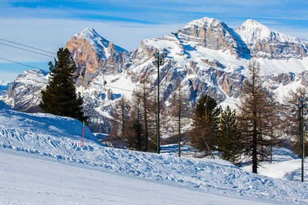Alpine ski lift with T-bar Alpine T-bar ski lift, slope with mountains in the background at Cortina d'Ampezzo Faloria skiing resort area Dolomiti Italy t bar ski lift stock pictures, royalty-free photos & images