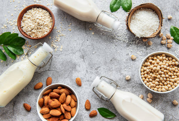 Alternative types of vegan milks in glass bottles Alternative types of vegan milks in glass bottles on a  concrete background. Top view calcium stock pictures, royalty-free photos & images