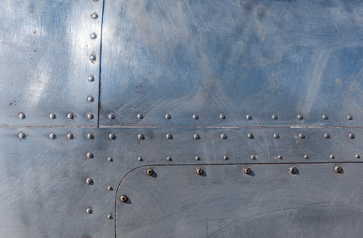 Weathered aluminum airplane fuselage with rivets background.
