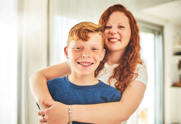 I am my brother's keeper Portrait of a cheerful brother and sister spending some quality time together at home dental braces photos stock pictures, royalty-free photos & images