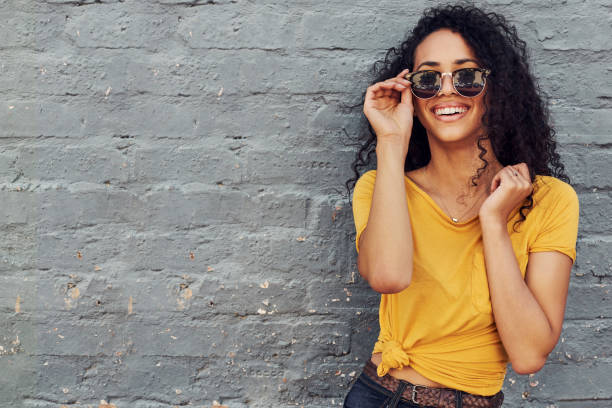 I am summer ready Cropped portrait of an attractive young woman wearing sunglasses and smiling while standing against a gray background outdoors beautiful latina woman stock pictures, royalty-free photos & images