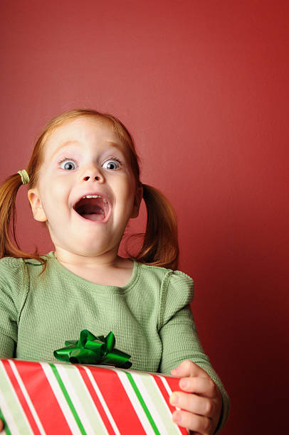 Amazed Little Girl with Christmas Present stock photo