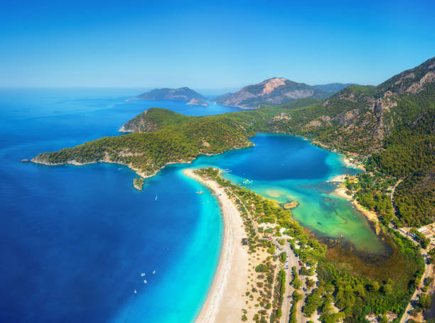 geweldige luchtfoto van de blue lagoon in oludeniz, turkije. zomer landschap met bergen en groene bossen, azuurblauwe water, zandstrand, blauwe hemel in zonnige dag. reizen achtergrond. bovenaanzicht. natuur - egeïsch turkije stockfoto's en -beelden
