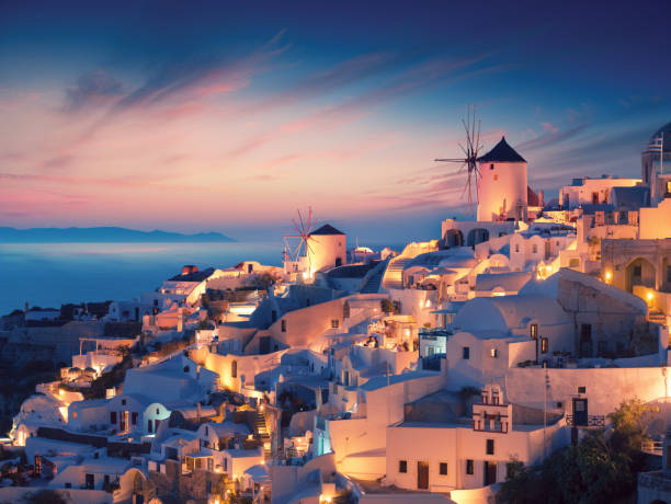 Amazing sunset view with white houses in Oia village on Santorini island in Greece. stock photo