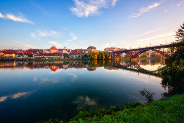 erstaunliche aussicht auf maribor altstadt, hauptbrücke (stari am meisten) auf der drau bei sonnenaufgang, slowenien. malerisches stadtbild mit blauem himmel und reflexion, reisehintergrund - maribor slowenien stock-fotos und bilder