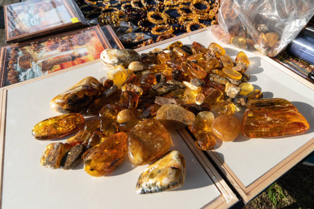 Amber stones on counter of street vendor. Real, not fake raw baltic amber stones for making jewelry and jewelery. Amber stones on counter of street vendor. Real, not fake raw baltic amber stones for making jewelry and jewelery. fossilized pitch stock pictures, royalty-free photos & images