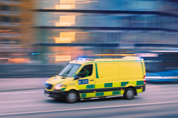 An ambulance driving through the city streets of Stockholm at speed.