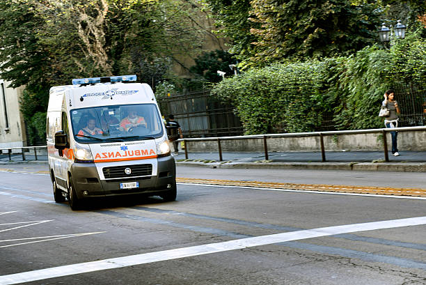 Ambulance running fast in Milan city centre street stock photo