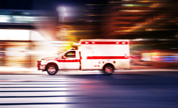 Ambulance speeding at night in New York City Ambulance speeding at night in New York City - motion blur panning action ambulance stock pictures, royalty-free photos & images