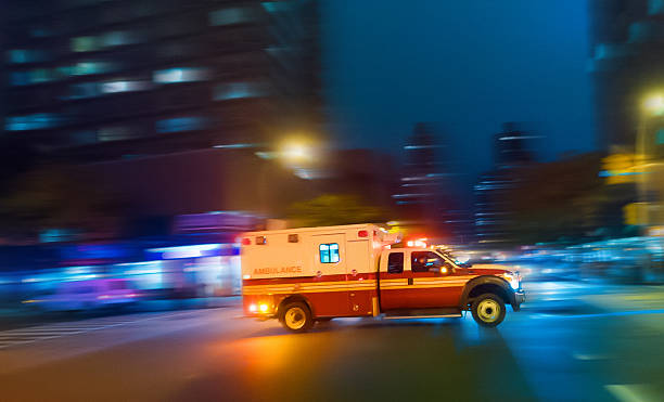 Ambulance speeding in New York Ambulance speeding at night on an urgent call in Manhattan New York - motion blur panning action ambulance stock pictures, royalty-free photos & images