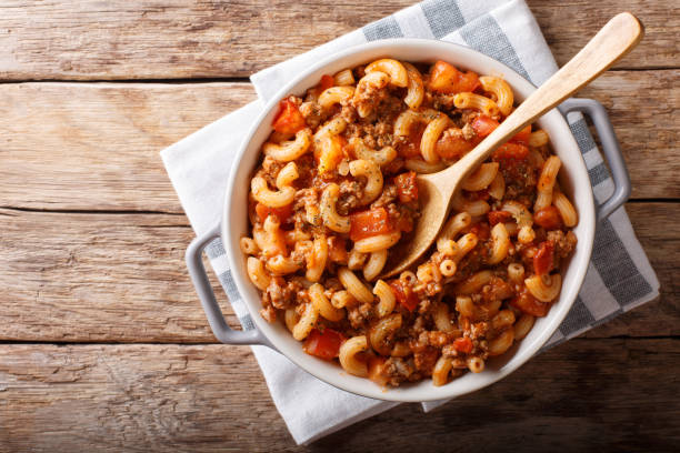 american chop suey, american goulash, with elbow pasta, beef and tomatoes close-up. Horizontal top view american chop suey, american goulash, with elbow pasta, beef and tomatoes close-up in a saucepan. horizontal top view from above macaroni stock pictures, royalty-free photos & images