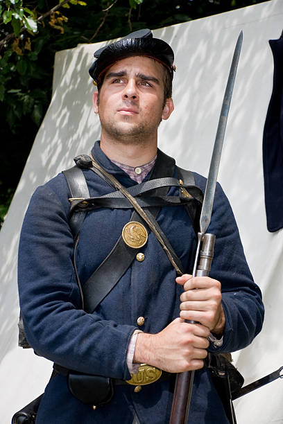 American Civil War, Union Soldier With Bayonet "A reenactor portraying the part of a Union soldier during the American Civil War, posing with his rifle and bayonet.  Tent in the background." historical reenactment stock pictures, royalty-free photos & images