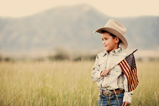 A young cowboy of Hispanic descent shows his colors on the Fourth of July.