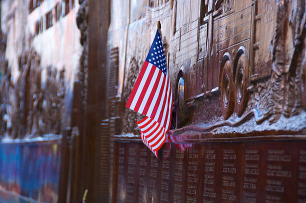 American flag at FDNY Memorial Wall, Ground Zero New York City, USA - May 6, 2011: A small American flag was left attached to the FDNY ( Fire Department of New York City) Memorial Wall that commemorates the 343 men killed on September 11, 2001. The scene is on the day after President Obama visited Ground Zero as thousands of people came to the site after the U.S. Special Forces killed Osama Bin Laden in Pakistan. It is located on the Liberty & Greenwich Street firehouse of Engine & Ladder No.10, across from Ground Zero, World Trade Center. 911 new york stock pictures, royalty-free photos & images