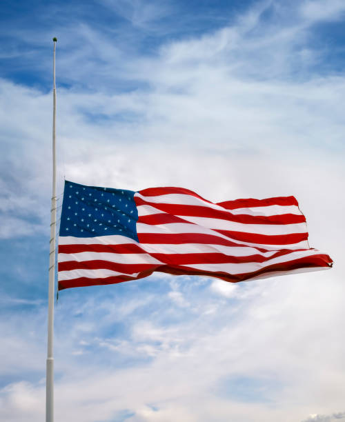 American flag at half mast background blue sky, sunny day, no people, windy with flag blowing, side view flag at half staff stock pictures, royalty-free photos & images