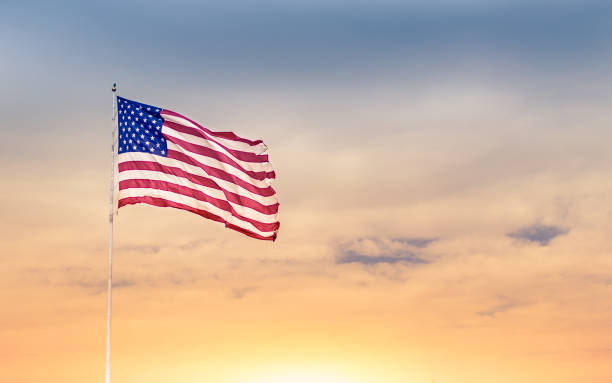 American flag American flag blowing in the wind against beautiful sunset. blowing photos stock pictures, royalty-free photos & images
