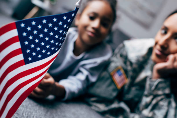 american flag african american daughter and mother in military uniform with american flag at home military stock pictures, royalty-free photos & images