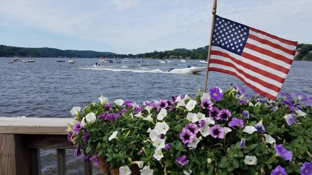 American Flag Waving Against a Water and Floral Scene stock photo